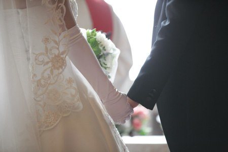 couple holding hands during marriage ceremony