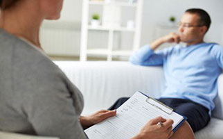 woman taking notes from man sitting on couch