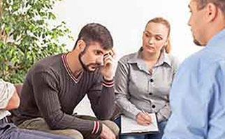 man in group therapy with counselor
