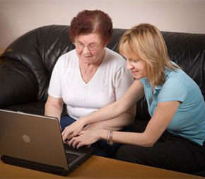 social worker on laptop with elderly client