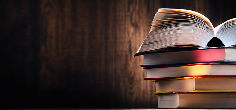 stack of books in front of wood wall