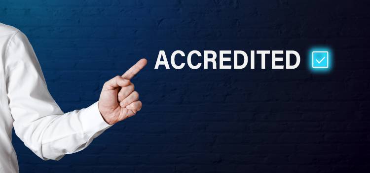 hand pointing to the word accredited