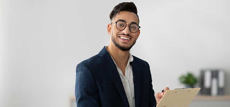 young man in suit holds clipboard