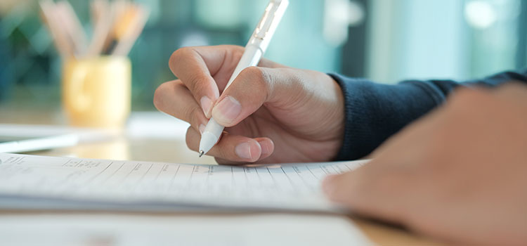 hand holding pen filling out form