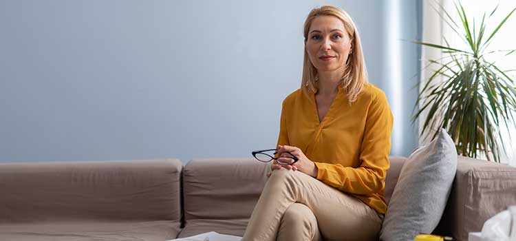 female therapist sits serenely on sofa