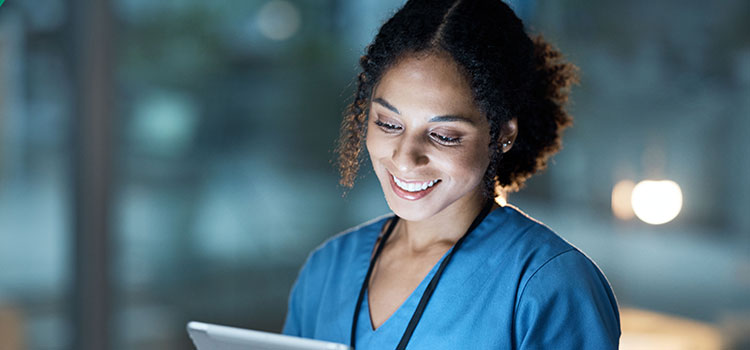 smiling nurse consults tablet vitals