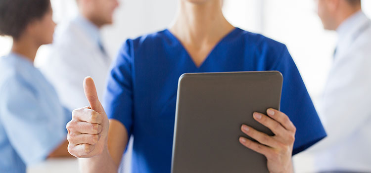 nurse holding tablet test results gives thumbs up