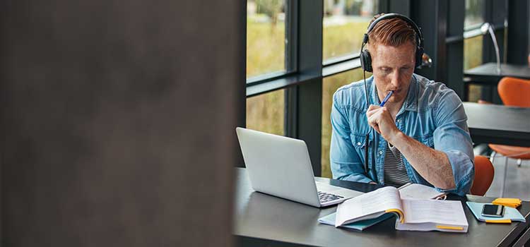 male student with headphones studying for exam