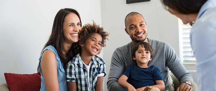 smiling diverse family talks to family counselor