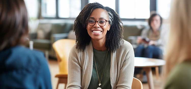 smiling counselor leads group of outpatient people