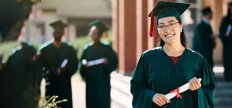 woman at college graduation holding bachelors in psychology diploma
