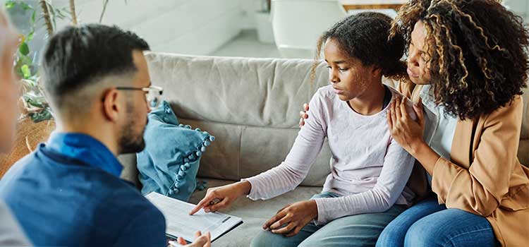 therapist listens to mom and daughter during a family session
