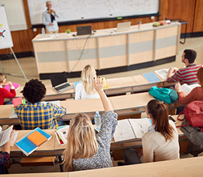 a human services student raises her hand in a college classroom